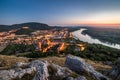 View of Lit Small City with River from the Hill at Sunset Royalty Free Stock Photo