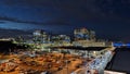 View of lit up buildings at night and a full parking lot