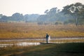 LOCAL FISHERMAN CASTING NETS FROM A SMALL BOAT IN A RIVER IN AFRICA