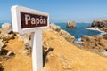 View of a location sign on the shores of Ilheu da Papoa under the blue sky