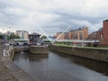 A view of the lock gates outside clarence dock in leeds with people on the island next to knights bridge and city apartment