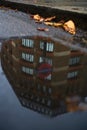 view of london building and tfl london underground tube sign in reflection of puddle