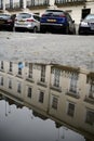 view of london street and cars in reflection of puddle