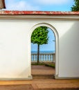 View of a lone tree by the sea through the stone arch Royalty Free Stock Photo