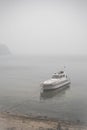 View on lonely boat and Lake Baikal under the fog Royalty Free Stock Photo