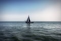 View of a lonely sailing ship with black sail, sailing on the turbulent barges of a Dutch lake