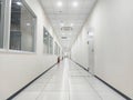 A view into a long corridor indoor inhouse glass window factory walkway led lighting white lighting