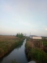 view of a long but medium-sized river near rice fields and also at a plastic waste incinerator. Royalty Free Stock Photo