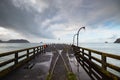 View from the longest wharf Tolaga Bay in New Zealand with dramatic clouds and reflective puddles Royalty Free Stock Photo
