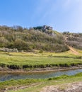 A view looking back across the Pennard Pill stream floodplain towards the castle ruins at the Three Cliffs Bay, South Wales Royalty Free Stock Photo