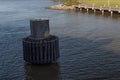 View looking down on a modern dolphin pier piling in the shadow of a ship