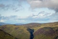 View looking east above Glen Doll towards rolling Scottish mountains with white clouds