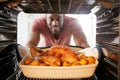 View Looking Out From Inside Oven As Man Cooks Sunday Roast Chicken Dinner Royalty Free Stock Photo