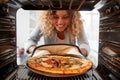 View Looking Out From Inside Oven As Woman Cooks Fresh Pizza Royalty Free Stock Photo