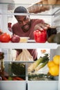 View Looking Out From Inside Of Refrigerator As Man Opens Door And Unpacks Shopping Bag Of Food Royalty Free Stock Photo