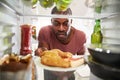 View Looking Out From Inside Of Refrigerator Filled With Unhealthy Takeaway Food As Man Opens Door Royalty Free Stock Photo