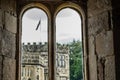 View looking out of a medieval, stonework window to a distant tower Royalty Free Stock Photo