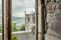 View looking out of a medieval, stonework window to a distant tower Royalty Free Stock Photo