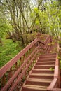 a view, looking up for the top of a long wooden staircase located in a forest. Part of a hiking trail and used to connect Royalty Free Stock Photo