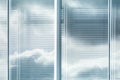 View of louvers window of modern office building with reflection of sky with clouds, blurred effect Royalty Free Stock Photo