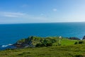 A view of the Lulworth Cove along the Jurrassic Coast in Dorset under a majestic blue sky and some white clouds