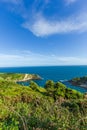 A view of the Lulworth Cove along the Jurrassic Coast in Dorset under a majestic blue sky and some white clouds Royalty Free Stock Photo