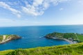 A view of the Lulworth Cove along the Jurrassic Coast in Dorset under a majestic blue sky and some white clouds