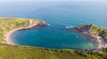 A view of the Lulworth Cove along the Jurrassic Coast in Dorset under a majestic blue sky and some white clouds