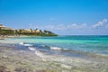 View at luxury resort hotel beach of tropical coast. Leaves of coconut palms fluttering in wind against blue sky Royalty Free Stock Photo