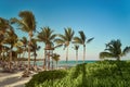View at luxury resort hotel beach of tropical coast. Place of lifeguard. Leaves of coconut palms fluttering in wind Royalty Free Stock Photo
