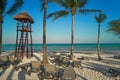 View at luxury resort hotel beach of tropical coast. Place of lifeguard. Leaves of coconut palms fluttering in wind Royalty Free Stock Photo