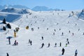 Skiers and snowboarders skiing down the slope. Active winter vacation in Italy, Europe