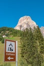 View of magical granite Dolomite peak, Sassongher, alpine pine and spruce forests, green valleys and a post sign showing direction Royalty Free Stock Photo