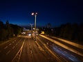 View of main road B9 leading through the center of Koblenz illuminated by lanterns with yellow light and cars passing by.