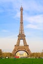 View of the majestic Eiffel Tower that rises from its park to a clear sky.