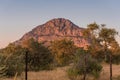 A view of the male hill at Tsodilo Hills, glowing pink during sunset. Tsodillo hills is a UNESCO world heritage site featuring