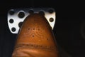View of male leg in elegant brown shoe on car brakes pedal