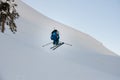 view of male skier making jump while sliding down snow-covered slope on skis Royalty Free Stock Photo