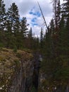 View of Maligne Canyon with narrow ravine between forest on cloudy day in autumn in Jasper National Park, Alberta, Canada. Royalty Free Stock Photo