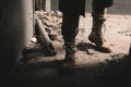 View of man in boots standing in weathered room, post apocalyptic concept