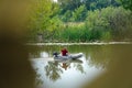 View of a man floating on a rubber inflatable boat with a motor Royalty Free Stock Photo