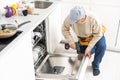 View Of Man In Overall Repairing Dishwasher In Kitchen Royalty Free Stock Photo