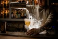 View of man pouring steaming drink from shaker cup into wine glass