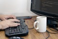 View of a man`s hands typing on his pc or computer keyboard at his home desk while working. Work at home concept Royalty Free Stock Photo