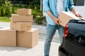 View of man standing near car while putting box Royalty Free Stock Photo