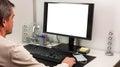 View of man using computer monitor with mockup image blank screen with white background for advertising text Royalty Free Stock Photo