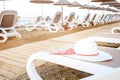 View on many deck chairs with summer white hat on one of them.