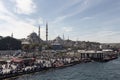 View of many people in Eminonu area in Istanbul. Historical mosques called Yeni and Yavuz Sultan Selim are in the view.