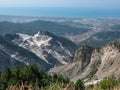 View of the marble Quarries of Carrara, the paths carved into the side of the mountain and the town of Carrara and the Coast in