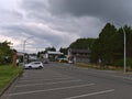 View of Market St in the downtown of Port Hardy, Vancouver Island with cars, buildings and trees on cloudy day.